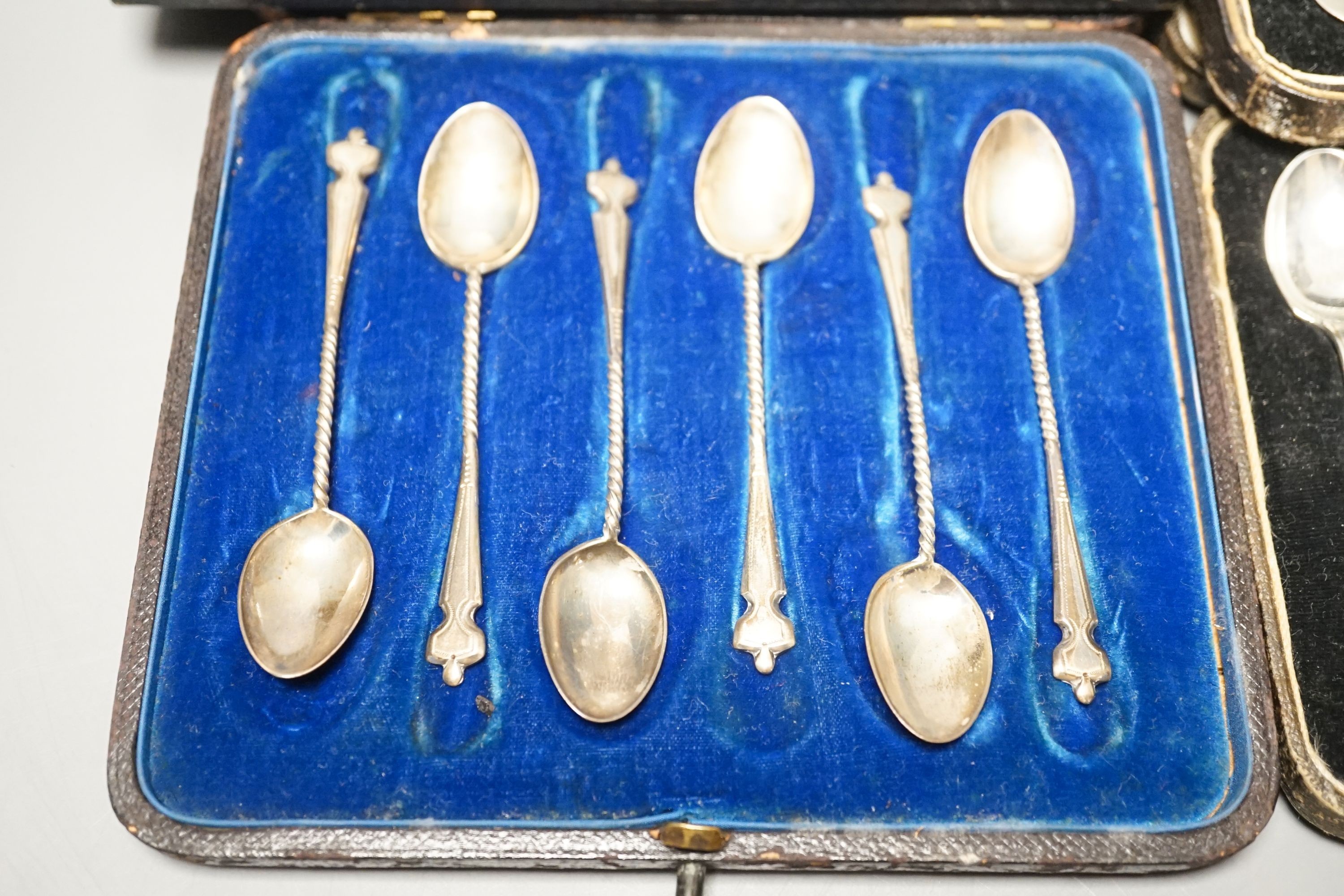 Four cased sets of cutlery including silver teaspoons and pair of silver preserve spoons and a silver cigarette case.
